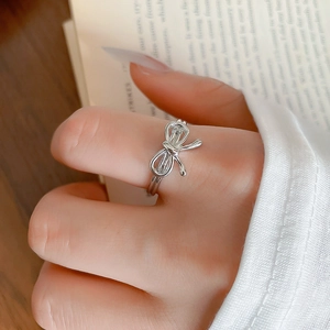 Gros plan d'une bague nœud argentée portée au doigt avec un décor de vie chaleureux