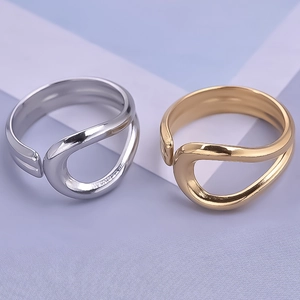Close-up of gold and silver minimalist open rings with fluid irregular curved design
