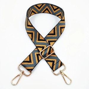 Macro detail of 3.8cm geometric tri-color woven shoulder strap with gold metal lobster clasp