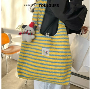 Close-up of yellow and blue striped plush tote bag with a cute puppy keychain