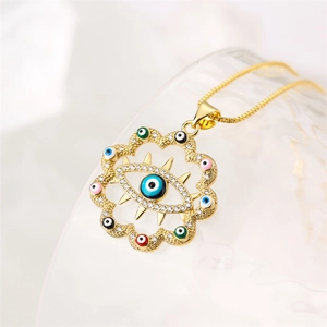 Détail macro du collier œil maléfique doré avec émail coloré et strass scintillants