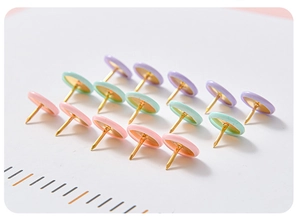 Close-up of macaron pink, green and purple push pins with golden metal needles