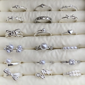 Elegant 925 sterling silver jewelry set featuring pearl and bow rings in a velvet box