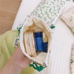 Close-up of green floral cotton coin purse showing interior capacity and soft fabric texture