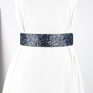 Detail of blue and silver rhinestone elastic wide belt on a white dress for party wear