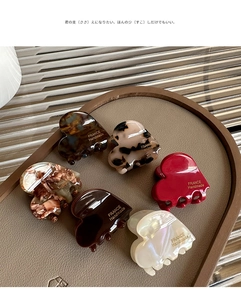 Detailed shot of six heart-shaped acetate claw clips with gold handmade lettering