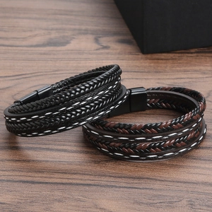 Braided leather bracelets in black and brown with magnetic clasp on a wood surface