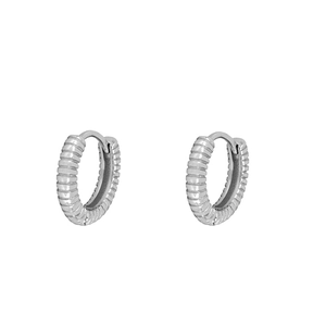 Detailed close-up of silver textured hoop earrings with a fine ribbed geometric pattern
