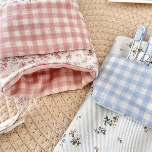 Detail of floral and plaid multi-purpose nurse pen pouches with dual-layer storage pockets