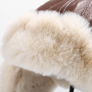 Detail of dark brown leather texture and thick cream faux fur on a winter aviator hat