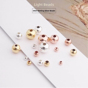 Detailed macro view of S925 sterling silver beads in gold, silver, and rose gold finishes