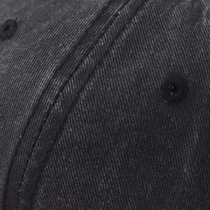Close-up of washed denim baseball cap featuring double stitching and embroidered eyelet