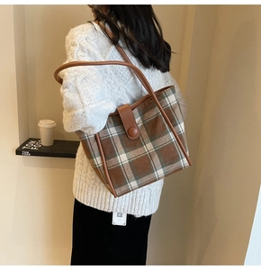 Detail of wool tote bag showing retro plaid fabric texture and leather shoulder strap