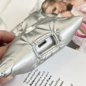Macro view of silver quilted AirPods case with charging port and pink hanging ring