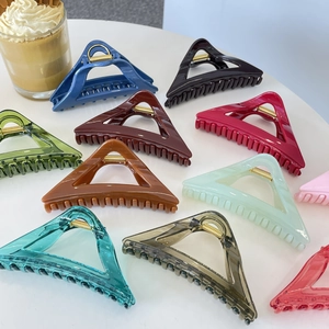 Detail of colorful 12cm triangular hair claws with glossy finish and metal springs