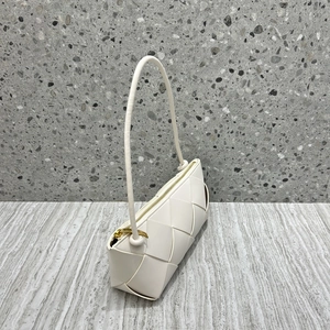 Detailed view of white woven leather texture and golden zipper on the square shoulder bag
