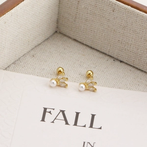 Close-up of gold s925 silver stud earrings with marquise zircon and pearl floral design