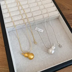 Collana con pendente a zucca in metallo spazzolato con catena a serpente oro e argento
