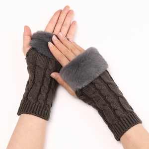 Close-up of dark brown cable knit arm warmers with grey faux fur trim and fingerless design