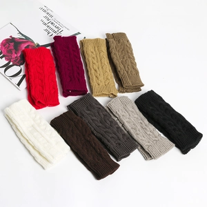 Macro shot of cable knit arm warmers in various colors including grey, red, and beige