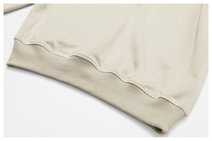 Détail macro de l'ourlet côtelé et de la maille beige d'un sweat-shirt à col rond