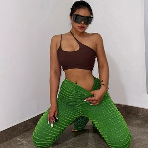 Détail du pantalon vert côtelé à taille haute avec texture à rayures horizontales et coupe ajustée