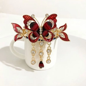 Elegant gold butterfly hair claw with red rhinestones and long tassel pendants