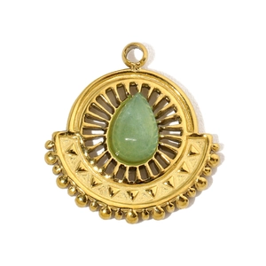 Detailed macro shot of the fan-shaped gold pendant with green teardrop stone