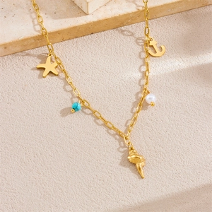 Gold plated ocean necklace with starfish, turquoise bead, pearl and shell charms on stone
