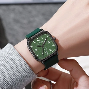 Close-up of forest green square quartz watch with textured dial on male wrist