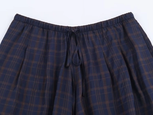 Detail of blue plaid shorts with elastic waistband and adjustable drawstring tie
