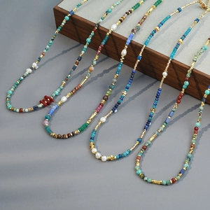 Bohemian beaded necklace set with African turquoise, coral, and pearls on wood display