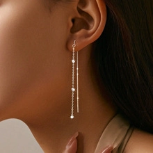 Détail d'une boucle d'oreille en argent S925 avec trois zircons sur un modèle