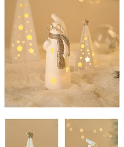 Detail of glowing ceramic Christmas snowman with gold glitter scarf and star cutouts
