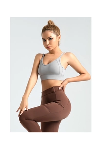 Detail of cross back sports bra with double straps and functional side pockets on leggings