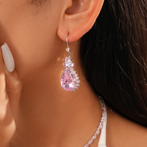 Detailed close-up of pink teardrop zircon earrings on model with floral silver setting