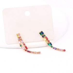 Close-up of long tassel earrings with colorful baguette-cut zircons in gold-tone setting