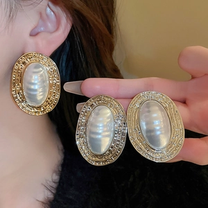 Vintage oval imitation pearl earrings with hammered gold metal frames in a French retro style