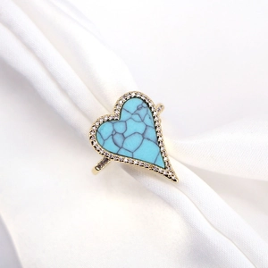 Gold heart turquoise ring with pave zircon borders on white satin fabric background