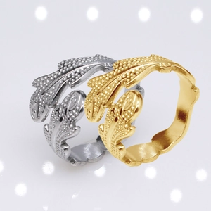 Macro detail of adjustable silver and gold feather rings with embossed metal textures
