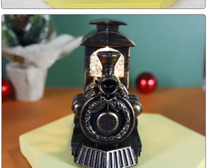 Close-up of vintage bronze Christmas train lantern with floral wreath and festive lights