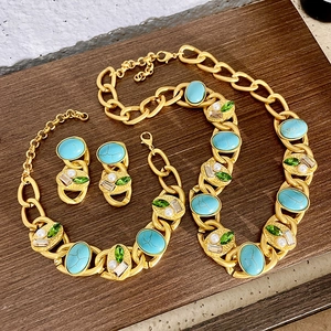 Detailed view of vintage gold chain jewelry set with turquoise, emerald gems and pearls