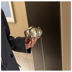 Close-up of a silver shell-shaped mini chain bag with mirror-like metallic finish