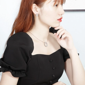 Modella indossa collana a ghirlanda oro rosa e orecchini di perle con zirconi
