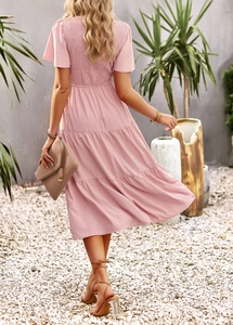 Back view of a pink short sleeve midi dress with smocked waist and tiered skirt layers