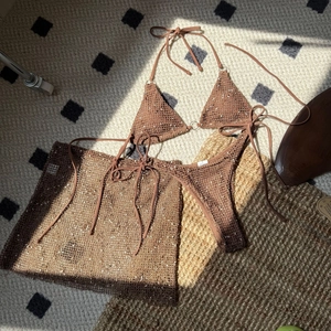Detailed texture of coffee crochet bikini set with mesh skirt on a textured background
