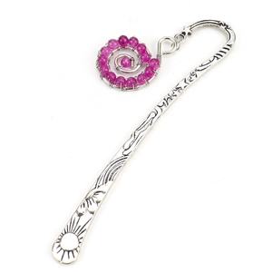 Detailed view of vintage silver bookmark with sun relief and pink beaded spiral pendant