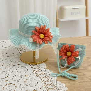 Dettaglio di cappello di paglia blu e borsa coordinata con girasole e pizzo bianco
