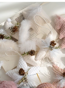 Detailed view of handmade Christmas plush star ornaments with pine cones and bells