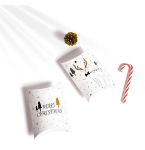 Macro view of white paper Christmas pillow gift boxes with festive patterns and Merry Christmas text